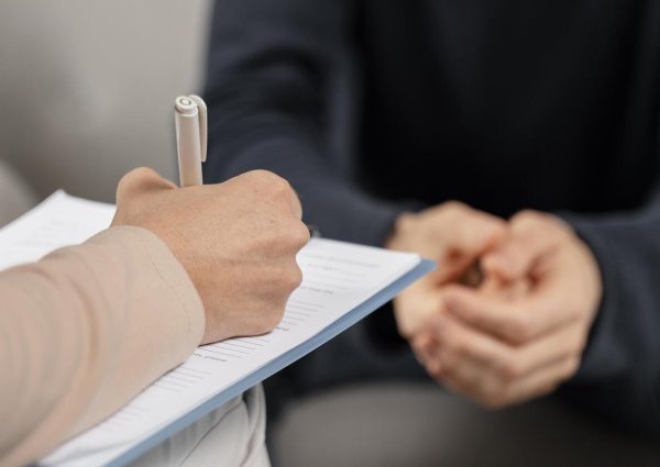 mid-shot-woman-therapist-taking-notes-clipboard
